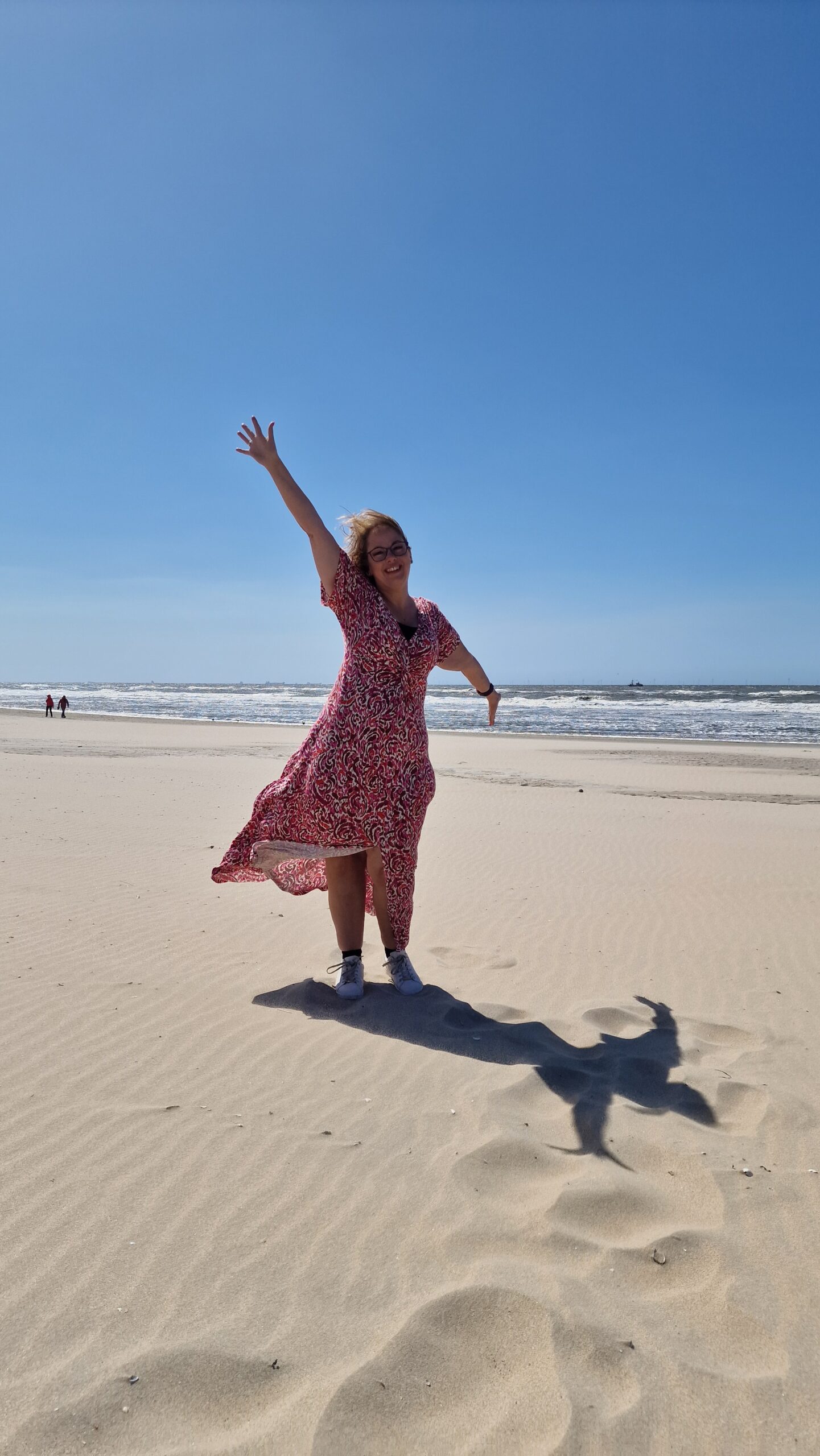 Mandy op het strand in een uitgewaaierde jurk